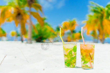 白色沙滩上两杯鸡尾酒图片