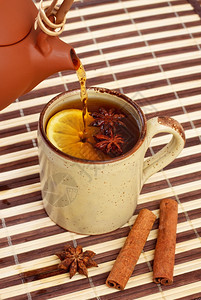 季节甜的杯子喝茶加肉桂和竹餐巾上的明星香肠图片
