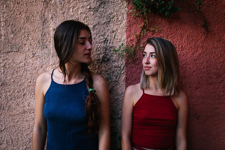 白种人漂亮的两个年轻天主教女青年看着两面彩墙的日落微笑图片