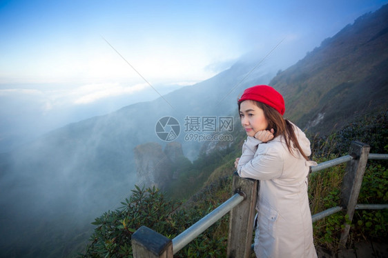 站在悬崖边的年轻女子俯视山上雾泰国人们土地图片