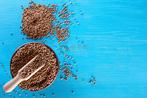 一种营养从上方的蓝背景视图健康天然食物概念配有小麦和木填充板的健康自然食物Clay碗的概念配有小麦和木填充板头图片