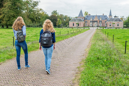 两个少女在通往城堡的路上带着背包走两个十几岁的女孩休闲吸引力纪念碑图片