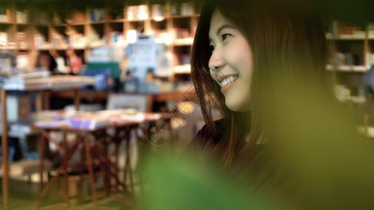 在线的饮料年轻在现代咖啡店和图书馆的幸福行动生活方式概念中临时穿便装的亚洲女商人肖像图片
