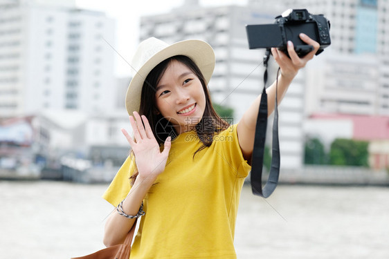 相机年轻女旅行者在城市户外背景中拍摄自照片旅游博客Vlog概念街道博主图片