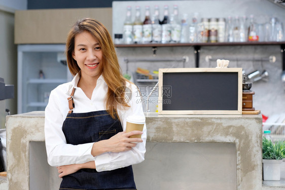 在咖啡馆柜台背景小商业主食品和饮料业概念上面带笑脸的可支配咖啡杯Pandlecoffeecup所有者店铺员工图片