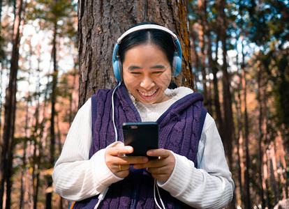 凉爽的小工具亚洲人在园艺技术和放松概念中亚洲年轻女孩听耳机音乐的亚裔青年女孩图片