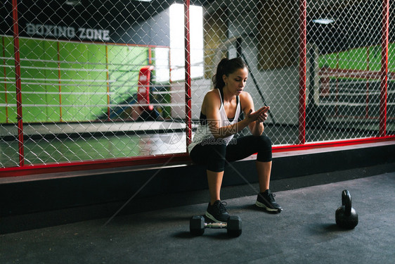 运动服在健身房休息的年轻黑发女人训练图片