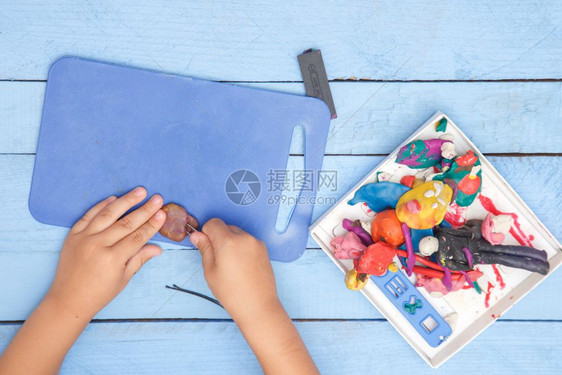 白色的黏土孩子们双手雕刻在一张蓝色表格上的粘土图从到下手指图片