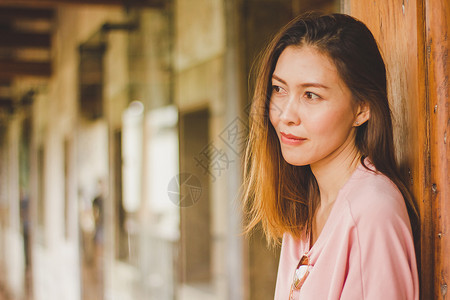 时髦女人靠在木门上站着蓝色的裙子图片