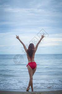 水太阳年轻美丽的亚洲女人在海滩上摆姿势淑女图片