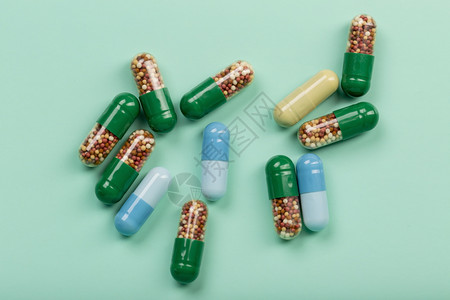 绿色背景上的胶囊药品图片