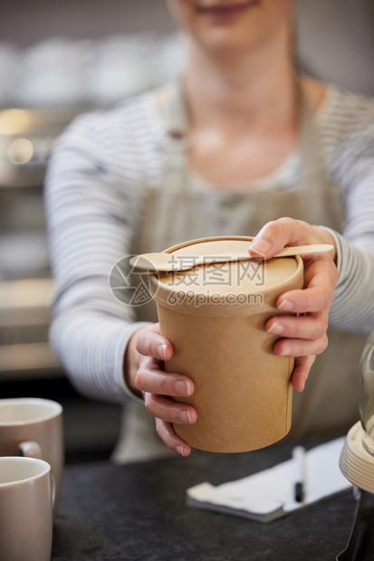 在与木质勺子可持续回收包装中为饭食提供物的咖啡厅近距离女工人纸板所有者五十年代图片