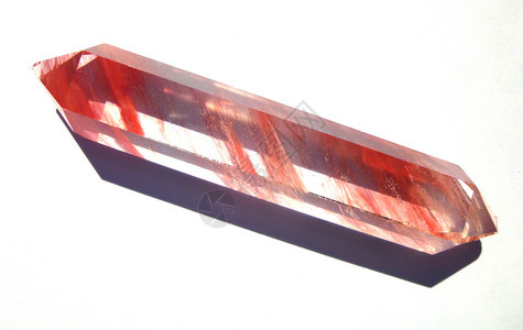 宝贵的标本灵气石英水晶宝透明与红色条纹隔离在白背景石英水晶宝透明与红色条纹图片