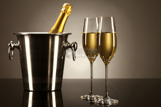 起泡的水晶两杯香槟和一桶瓶装在子上镜的一桶香槟酒还有点亮光两杯香槟加一个桶液体图片