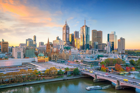 澳大利亚黄昏时墨尔本市天际线反射建筑学摩天大楼图片