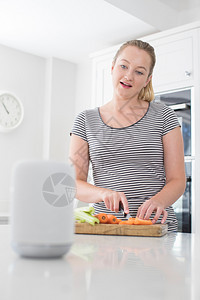 白种人在家庭询问数字助理时准备食物的妇女问题二十多岁艾图片