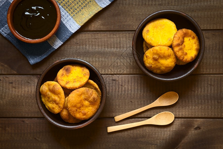 小吃传统智利索帕皮亚油炸糕饼的上头镜用面袋中的南瓜泥土豆做成配有香卡加甜酱用天然光照在黑木上面团平坦的图片