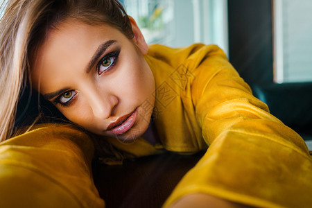 20多岁咖啡店紧贴近的年轻美女肖像仰靠在桌子上望着摄影机模型长发美丽的双眼头发图片