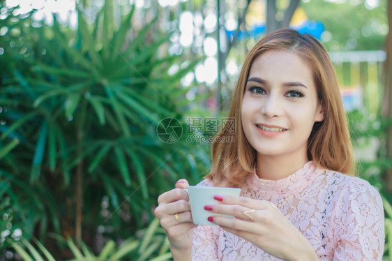 女孩亚洲商人在户外工作和喝咖啡在户外工作年轻的白种人图片