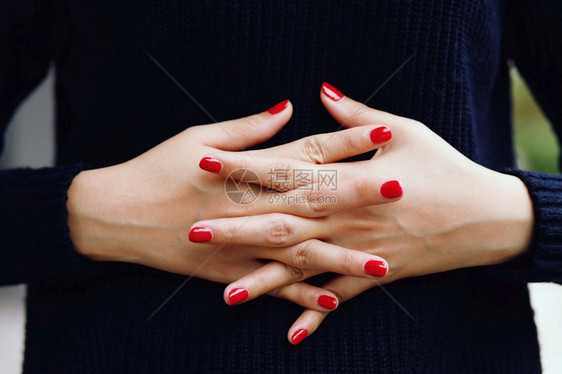 丰富多彩的修剪整齐美丽女指甲红钉紧贴花瓣时尚图片