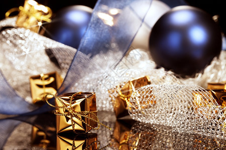 圣诞装饰前的金色小圣诞礼物装饰前的闪亮金色圣诞小礼物球和丝带金属新的杰出图片