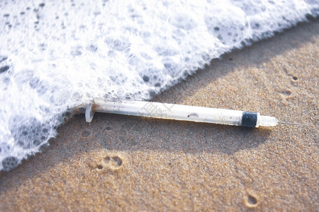生态感染物沙滩上的医疗注射器废物和泡沫传染废物管理概念废物的概念图片