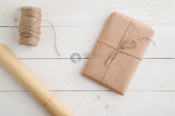 复制空间丝带包装在生态友好型纸和麻绳中用浅木背景包装从上到下饰风格图片