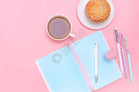 纸笔记本最小的办公室设计用品热茶和粉色糊面上蛋糕最起码的风格图片