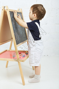 在黑板上画画的小男孩图片