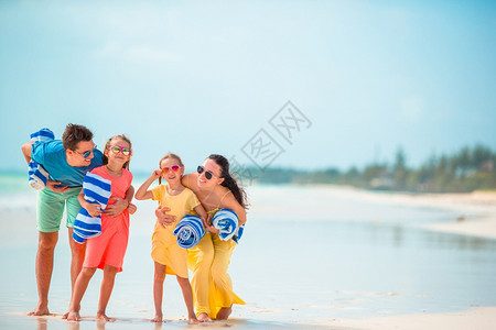 女热带幸福快乐美满的一家在海滩上四口人家多好微笑图片