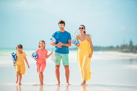 水海岸线家在沙滩度假幸福快乐美满四人家庭在沙滩上美丽的图片