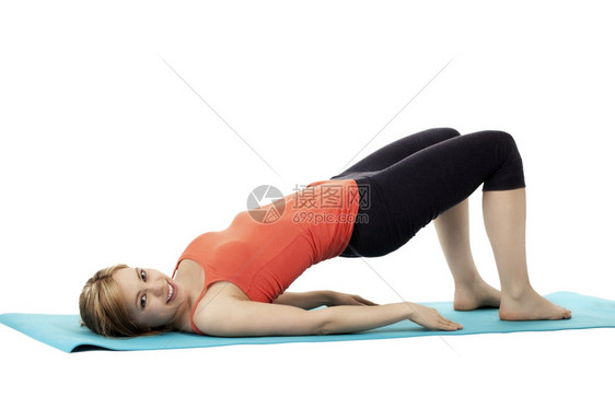 合身在一个长相的年轻快乐健身妇女上运动在白底蓝垫子上锻炼色的白图片