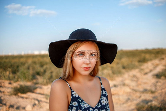 看女日落时在葡萄园中摆放着一个戴黑帽子印有花粉的女红裙子和白的金发蓝眼睛女孩的近视肖像化妆品图片