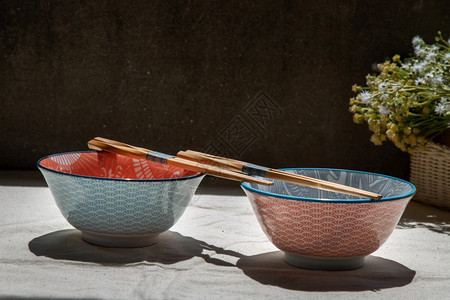 手工制作的陶瓷餐具美丽安排有选择的焦点等两个瓷碗加木筷子在卡利布料面上安装木棍材料时髦的图片