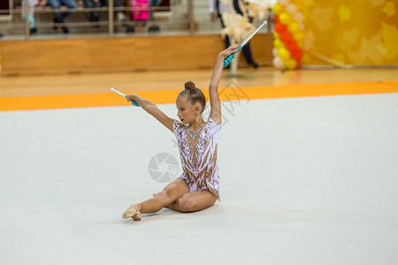 有氧运动杂技微笑美丽的小体操女郎在比赛的地毯上表演美丽的运动女郎在地毯上表演她的在地毯上出她非常活跃图片