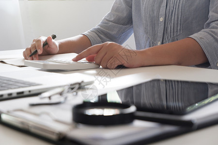 金融便携的利用式计算机设备通过手提笔记本电脑年轻女经理对在办公室工作的专业商妇女形象进行裁剪单位女白色的图片