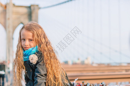 布鲁克林大桥上的漂亮女孩肖像纽约市美国曼哈顿坐在纽约布鲁克林大桥上的可爱小女孩快乐的外部观光图片