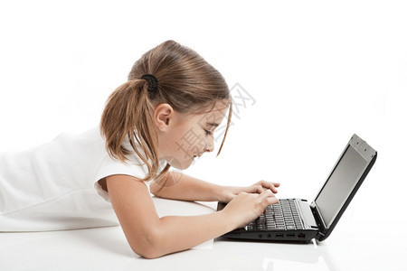 工作室技术小女孩躺在地板上用笔记本电脑工作颜色图片