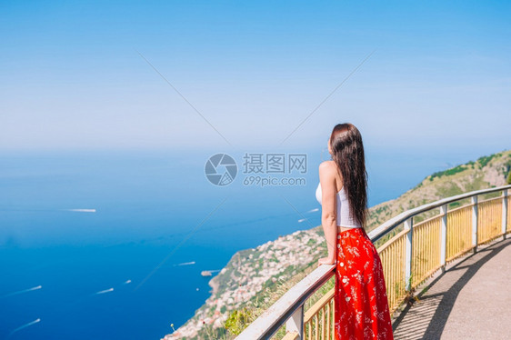 意大利村庄和蓝色海背景的年轻女子意大利阿马尔菲海岸意大利的暑假阿马尔菲海岸波西塔诺村庄背景的年轻女子帽美丽图片