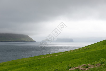 典型的法罗群岛地貌如Kirkjubour岛所见绿草山和海云伯格背景图片