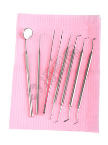 在职的镜子白底孤立粉红色小斑点上的牙科手术器械磨光机图片