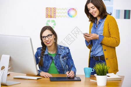 指点妇女在办公室工作创造办公室团队工作的妇女年轻时髦图片