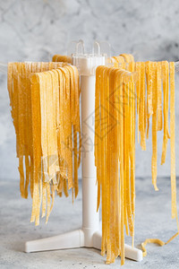 食谱意大利语制造自意大利面条挂在晾衣架上新鲜面条在晾衣架上晒自制意大利面在晾衣架上干图片