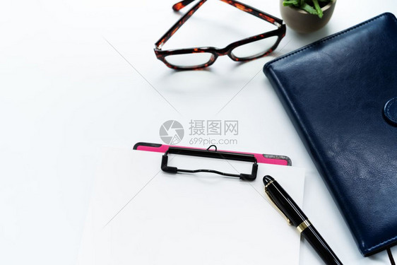 会议记事本和带空白页的剪贴板本日记上的眼镜有复制空间的白色背景床单图片