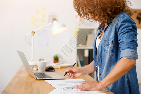现代的年龄工作办公室使用笔记本电脑的中年妇女图片