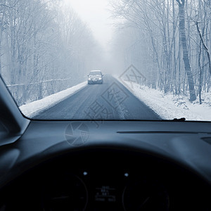 驾驶员在冬季风景中驾驶汽车从一辆内部驶走一条滑雪路上的司机眼目视该车为冬季安全驾驶概念眼睛运动仪表盘图片