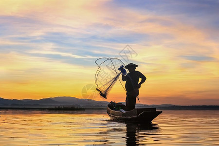 亚洲人日出时在河上船的鱼网被浸泡在水里早晨渔夫图片