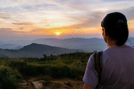 美丽的在泰国清莱省PhuChiFa森林公园观光点山上日落时女游客在多彩天空的美丽外观中看貌自然明亮的图片