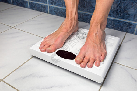 检查损失秤女脚站在浴室的测量体重比例表上以衡量体重图片