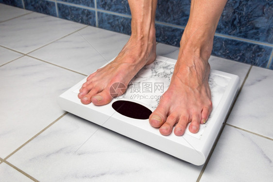 检查损失秤女脚站在浴室的测量体重比例表上以衡量体重图片